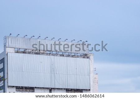 Blank Large Flip Billboard with Texture Install at Building Side for Advertising Concept, Communication Sigh Design for Business Promotion Information, Banner Background with Copy Space and Blue Sky