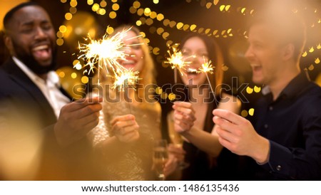 Overjoyed young people celebrating new year, holding bengal lights, having fun