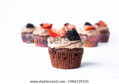 chocolate cupcakes with strawberry and blackberry in white background