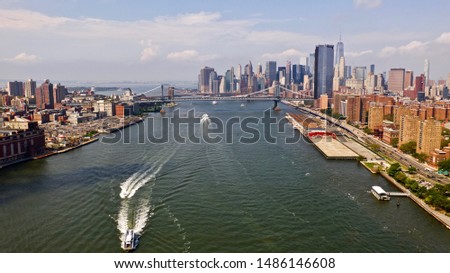aerial shot over New York City's East River with Lower Manhattan, NY, Manhattan, Brooklyn and Williamsburg Bridges in View