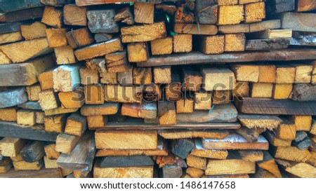 Sawn hardwood square or rectangular firewood stacked in a woodpile