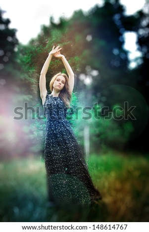 Dreamy photo of yong pretty woman in a fairy forest. DefocusedLooking At Camera