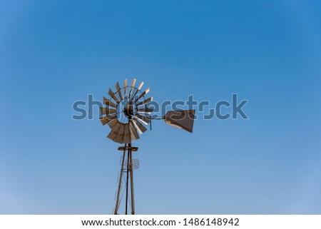 An old windmill against a blue sky in the town of Sutherland The windmill is metal. Cyprus