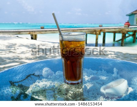 A glass of cold cocktail on a table on the beach in a restaurant