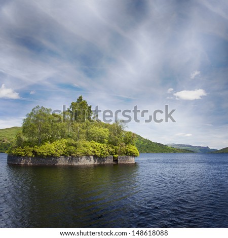 Fresh water lake in the scottish highlands, Lock Katrine. Pictured is Factors isle, where Walter Scott famously wrote a poem. The lake is also the water supply for the city of Glasgow. 