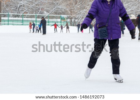 Blurred image of people moving on an ice rink, copy space.