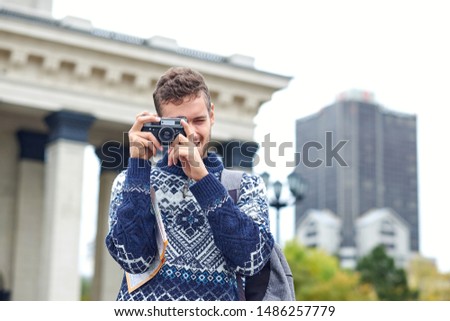 Traveling Man tourist backpackers taking photo on retro camera