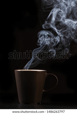 coffee brown mug and smoke on black background