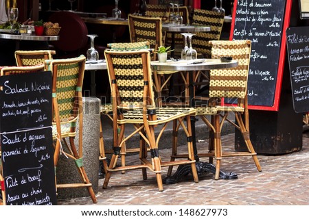 Cafe at rue Mouffetard in Paris - traditional wicker furniture and menu boards exposed on the pavement, Paris, France Royalty-Free Stock Photo #148627973