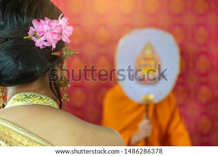 The bride listens to the monks chanting in a Thai wedding ceremony.