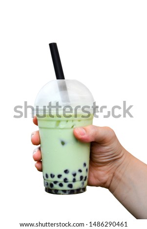 clipping path, close up hand holding glass of milk bubble matcha green tea with tapioca pearls isolated on white background