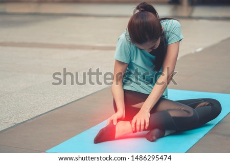 woman suffering or injury leg after do yoga. mature female or senior has pain in his foot or shin while exercise or warm up. sport girl hurting holding painful sprained ankle in pain. safety, health Royalty-Free Stock Photo #1486295474