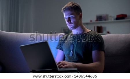 Serviceman searching job on laptop at home, adapting to civilian life after army Royalty-Free Stock Photo #1486344686