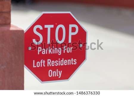 STOP - Parking for Loft Residents Only sign, close up with concrete in the background.