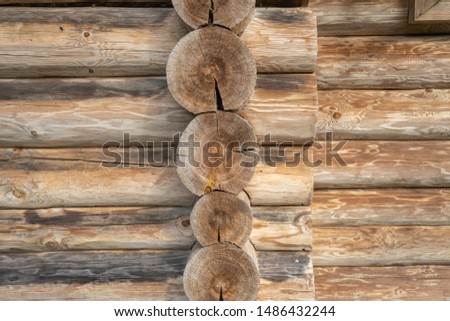Logs background. Old house of larch. Details of connection of corners. Texture of an old wooden house close-up. Ancient architecture. Space for text
