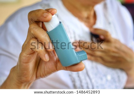 Elderly Female's hand use inhaler while difficulty of breathing.Medication for relief bronchospasm or Dyspnea from asthma attack or allergy,that's an emergency condition.Healthcare and medical concept Royalty-Free Stock Photo #1486452893