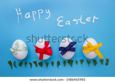Eggs on blue background with ribbons. Happy easter