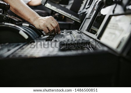 Man pushing buttons on control panel in cabin stock photo. Airways concept