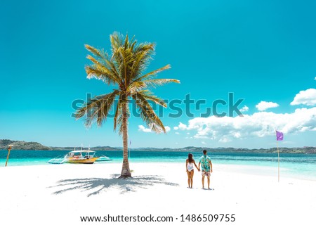 Couple spending time on a beutiful remote tropical island in the philippines. Concept about vacation and lifestyle.