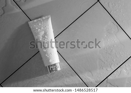 cosmetic mockup cream bottle pakage with beauty spa treatment and fresh water on bathroom floor