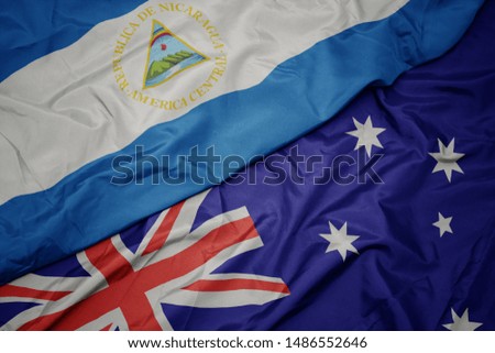 waving colorful flag of australia and national flag of nicaragua. macro