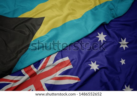 waving colorful flag of australia and national flag of bahamas. macro