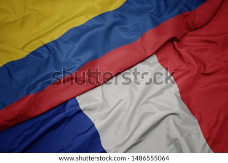 waving colorful flag of france and national flag of colombia. macro