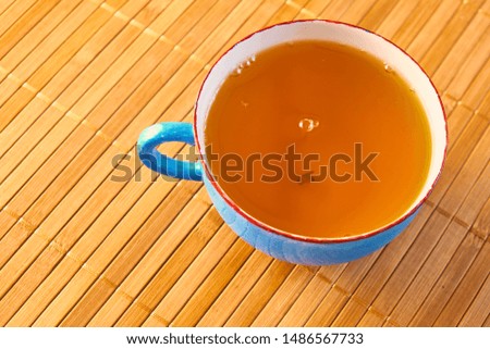 Blue cup of tea isolated on a bamboo table background 