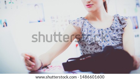 Portrait of smiling young woman with camera sitting in loft apartment