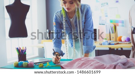 Fashion designer woman working on her designs in the studio