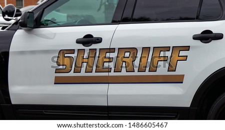 Side view of Sheriff's car door with SHERIFF text symbol. Royalty-Free Stock Photo #1486605467