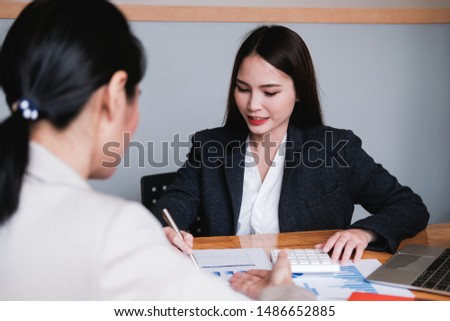 Friendly caucasian female mentor manager supervise secretary helping coworker with graph and paperwork at office desk, apprentice, teamwork and mentoring concept