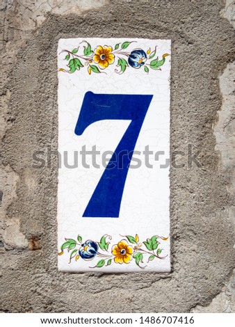 Number 7, seven, street number sign on the wall