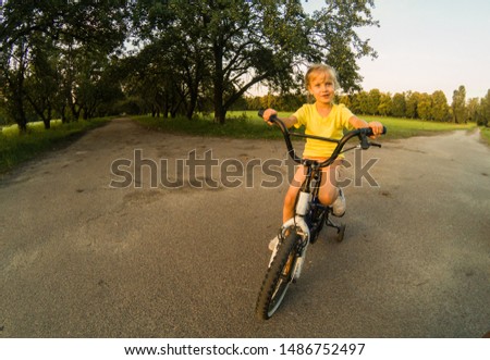 Little girl with riding bike at sunset