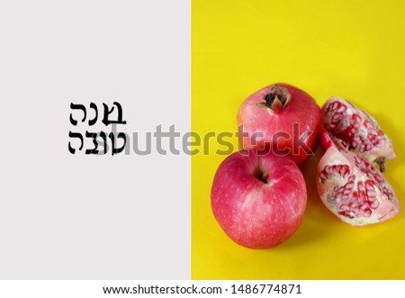 This is a picture of apple and pomegranate on a yellow background that has a Hebrew text that welcomes a Happy New Year in honor of a Jewish holiday called Rosh Hashanah