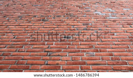 Detailed close up view on an aged and weathered red brick wall texture in high resolution