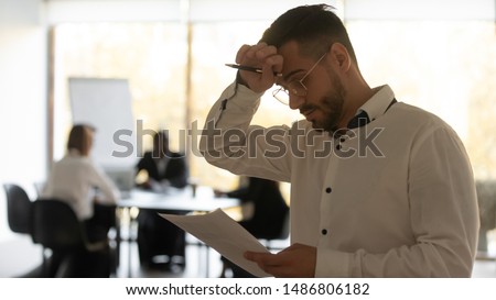 Stressed sweaty inexperienced businessman male speaker sweating wiping sweat holding paper reading preparing for speech feeling nervous worried tedious waiting afraid of public speaking fear concept Royalty-Free Stock Photo #1486806182