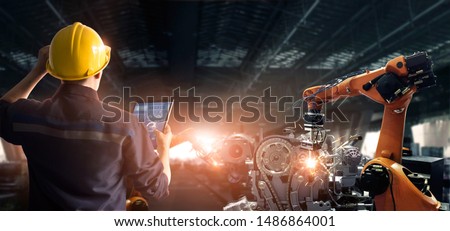 Engineer check and control welding robotics automatic arms machine in intelligent factory automotive industrial with monitoring system software. Digital manufacturing operation. Industry 4.0 Royalty-Free Stock Photo #1486864001