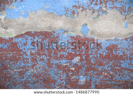 blue and red cracked paint on cement wall with texture and background