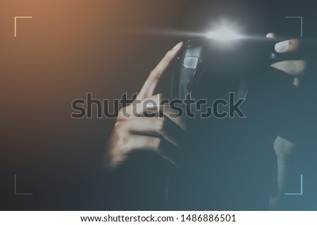 Blur of Professional photographers holding cameras and flash taking a photo with background look mysterious for photography or undercover agents. Detective or secretly taking pictures and stalking.