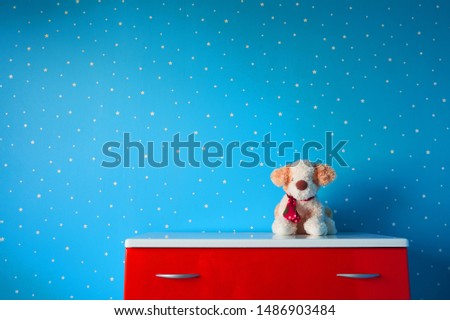 Cute stuffed white brown puppy toy in beautiful blue starry nursery