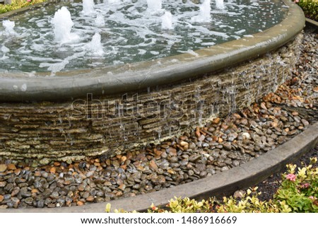 A fountain made of bricks and a beautiful garden for resting. Royalty-Free Stock Photo #1486916669