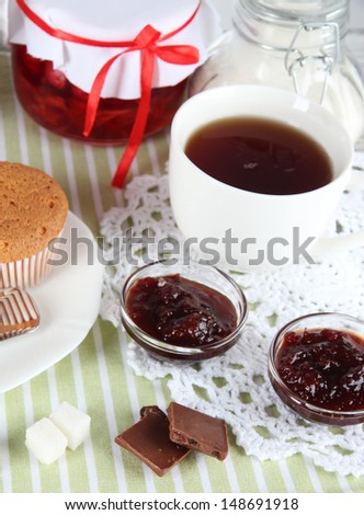 Yummy jam in bank on napkin on wooden table