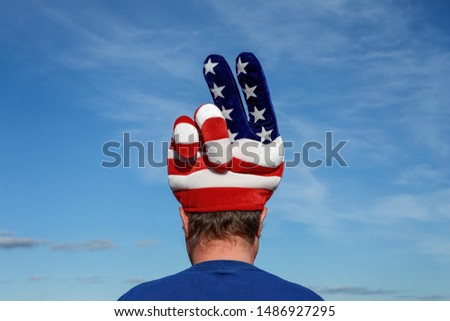 Man wearing an American patriotic peace sign hat with stars and stripes
