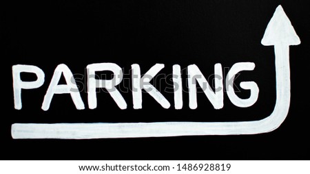 A sign of parking with white letters and black background