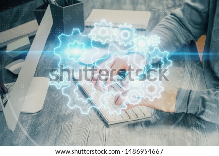 Multi exposure of businessman working on laptop on background. International business hologram in front. Concept of success.