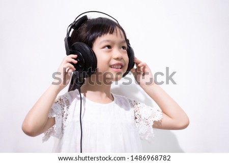 little cute girl enjoying listening music by headphone isolated on white background