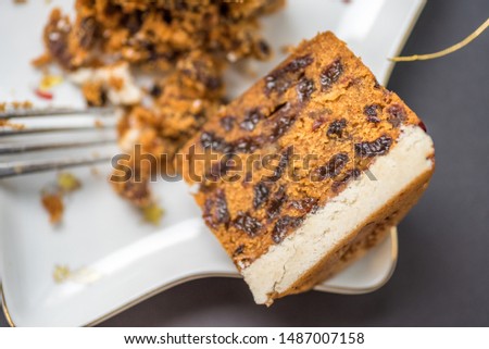 closeup view christmas mini cake crushed with fork on star shape plate with decorations