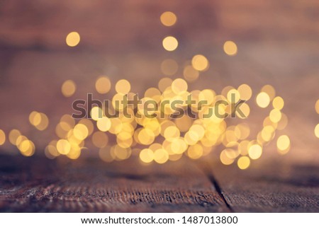 Gold rays of light with bubbles and glitters on wooden background