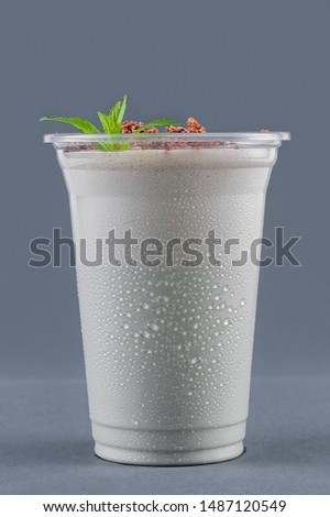 Milkshake with mint and chocolate chips on a gray background